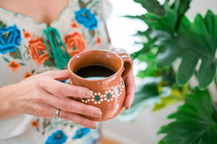mulher segurando uma xícara de café de olla em uma xícara barroca de cerâmica mexicana