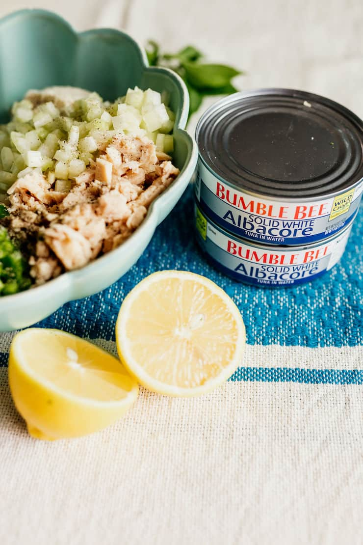 2 latas de atum albacora branco sólido com um touro de ingrediente para fazer um bolo de massa de atum e um limão na lateral