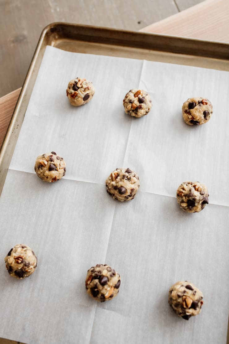 bolas de massa de biscoito em uma folha de biscoito forrada com pergaminho