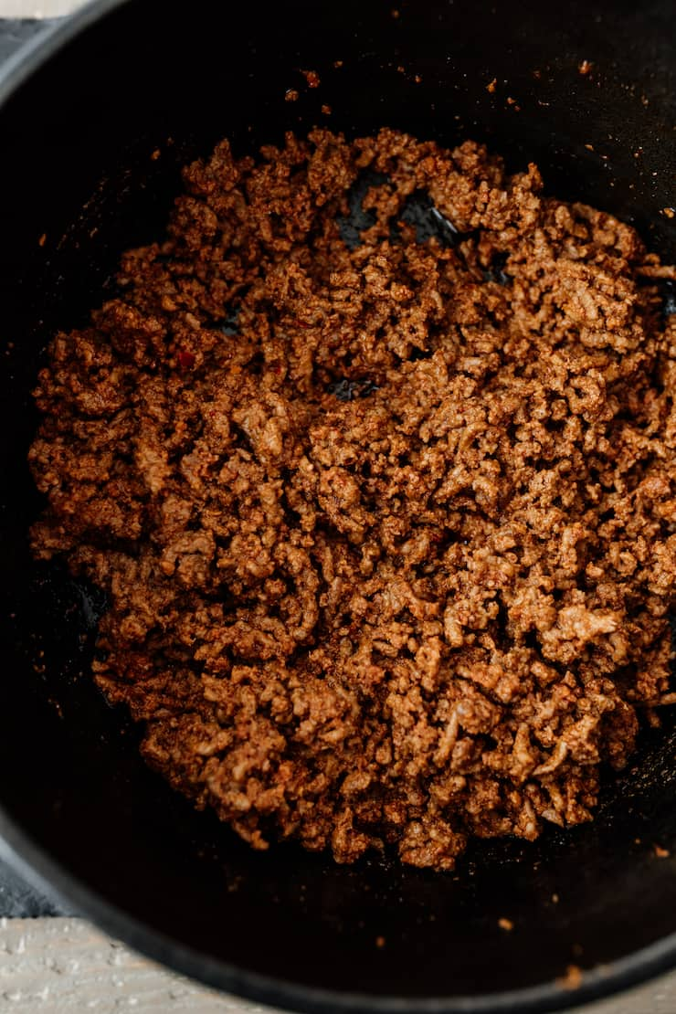 chouriço e carne moída misturados a castanho num forno holandês para pimentão com carne
