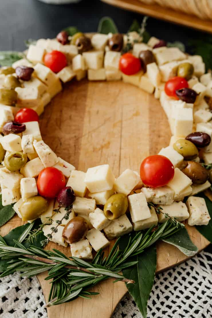 fechar uma tábua de queijo salgado estilo coroa de natal numa bandeja de madeira
