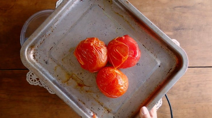três tomates em uma frigideira de lençol