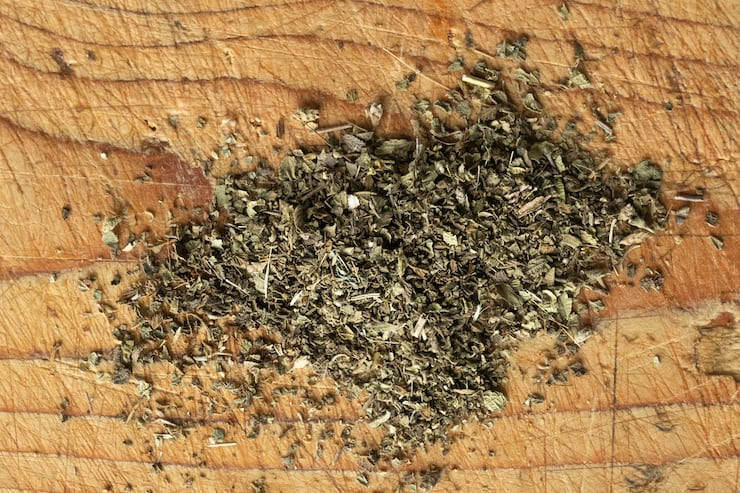 Oregãos secos salpicados sobre uma superfície de madeira