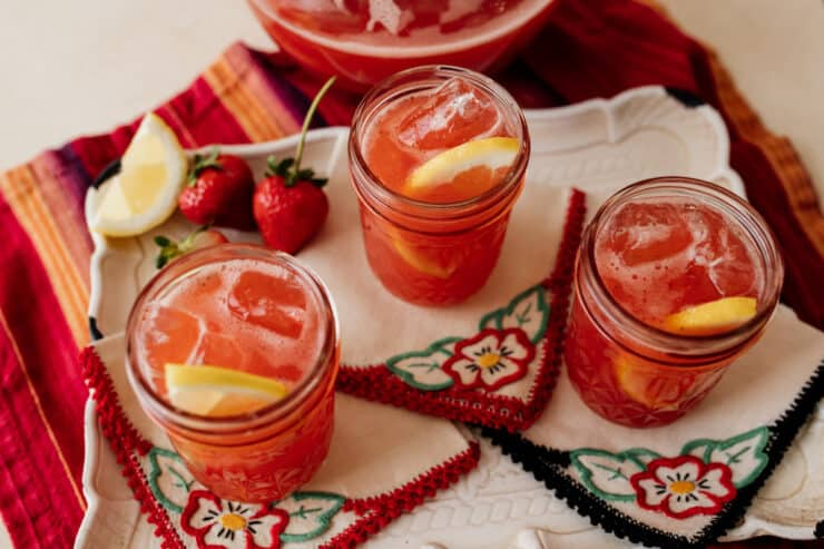 três boiões de chá doce de morango em guardanapos de cocktail bordados à mão