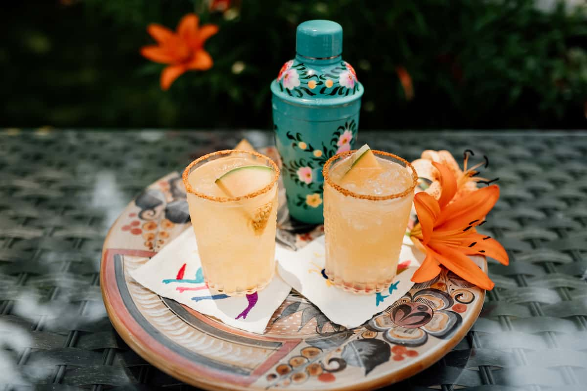 dois Cantaloupe Melon Margaritas em uma travessa mexicana e um coqueteleira turquesa pintado a mão