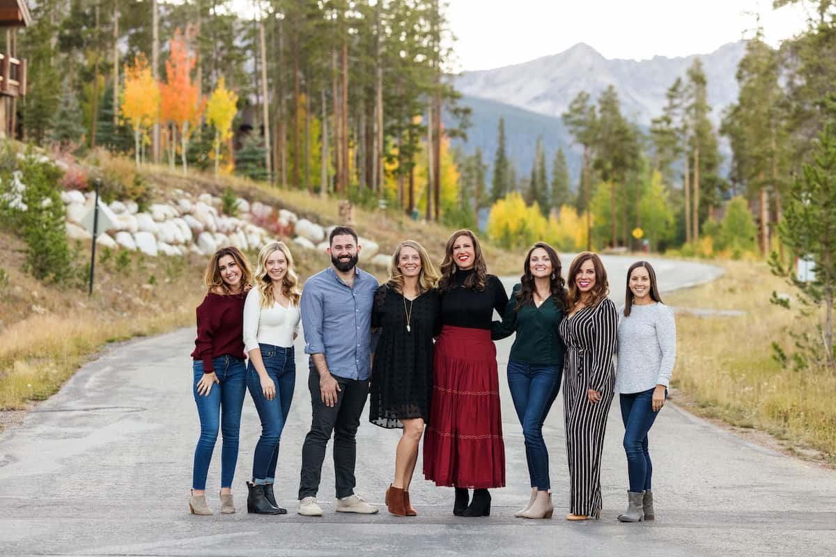Os participantes do Retiro Ar Fresco -- 8 blogueiros de pé com árvores e montanhas do Colorado ao fundo