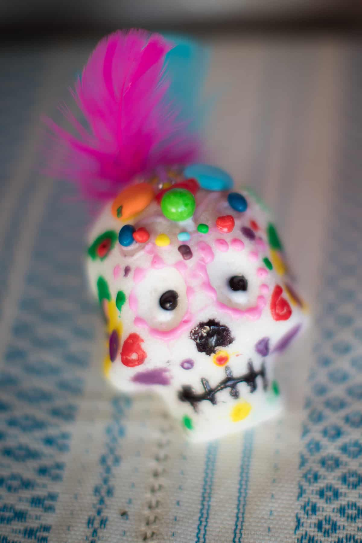 um crânio de açúcar colorido para o Dia de los Muertos com tinta, penas e missangas
