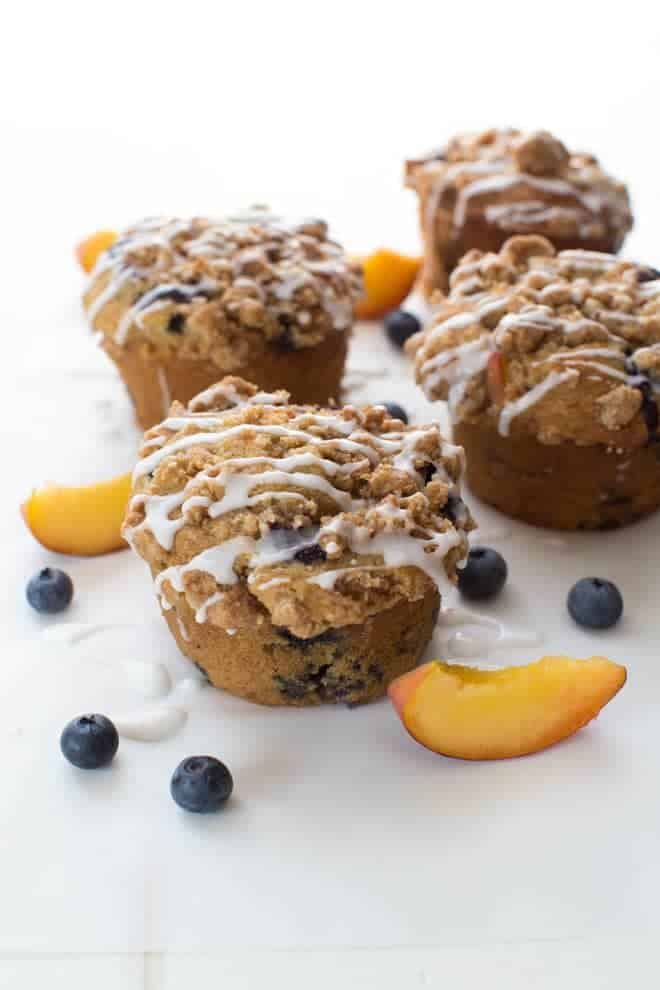 Os muffins Blueberry Peach Cobbler são perfeitos para a temporada de verão! Esta receita faz muffins de tamanho gigante cheios de pêssegos suculentos e mirtilos maduros!