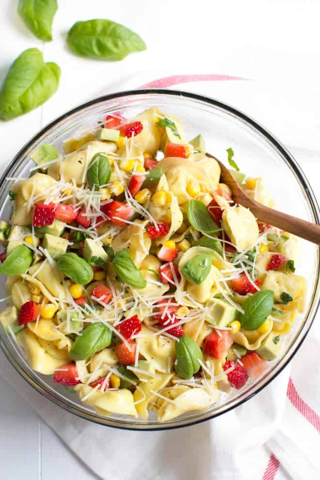 Salada de Morango, Milho e Abacate Tortellini é uma refrescante salada de verão feita com morangos, milho, abacate, manjericão, queijo parmesão e um simples molho balsâmico!