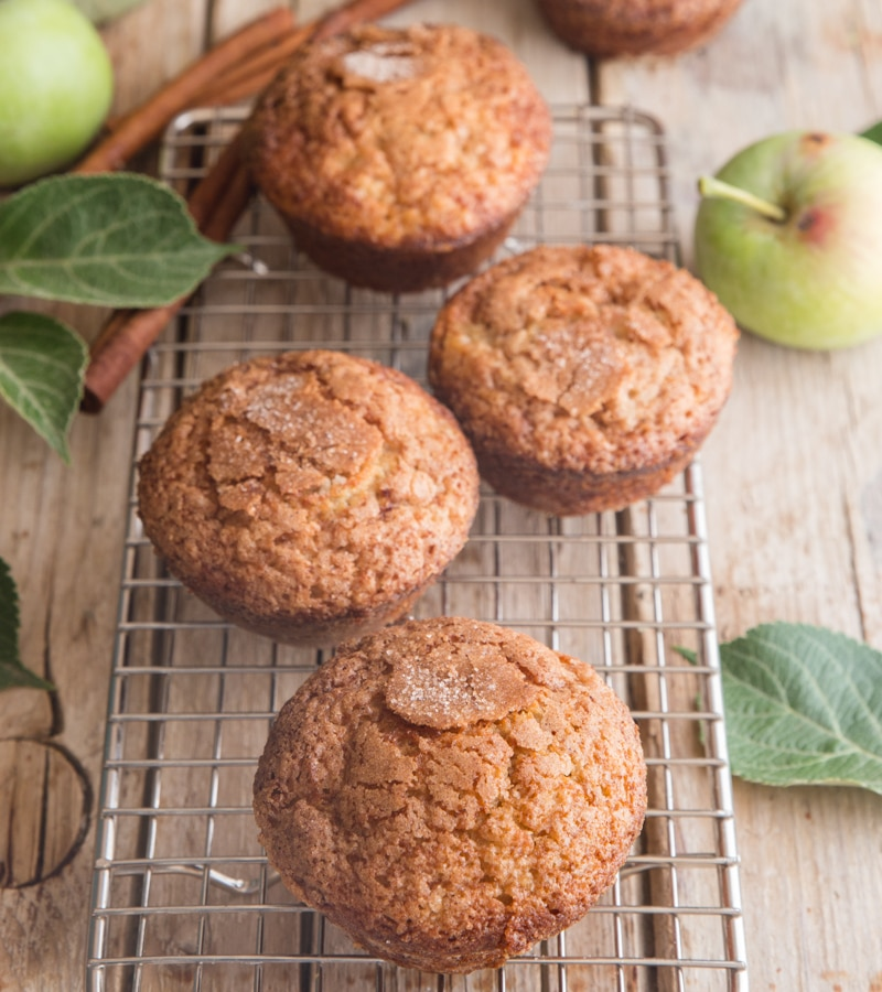 muffins de maçã em uma tábua de madeira com molho de maçã em um recipiente e maçãs
