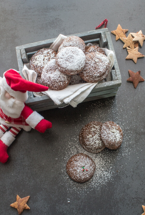 biscoitos numa caixa de madeira cinzenta com o Pai Natal encostado a ela com 3 biscoitos no tabuleiro