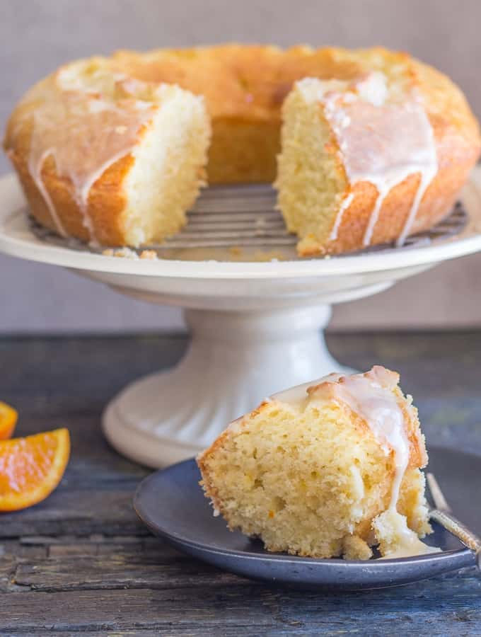bolo de laranja em uma banca de bolo com um pedaço em um prato