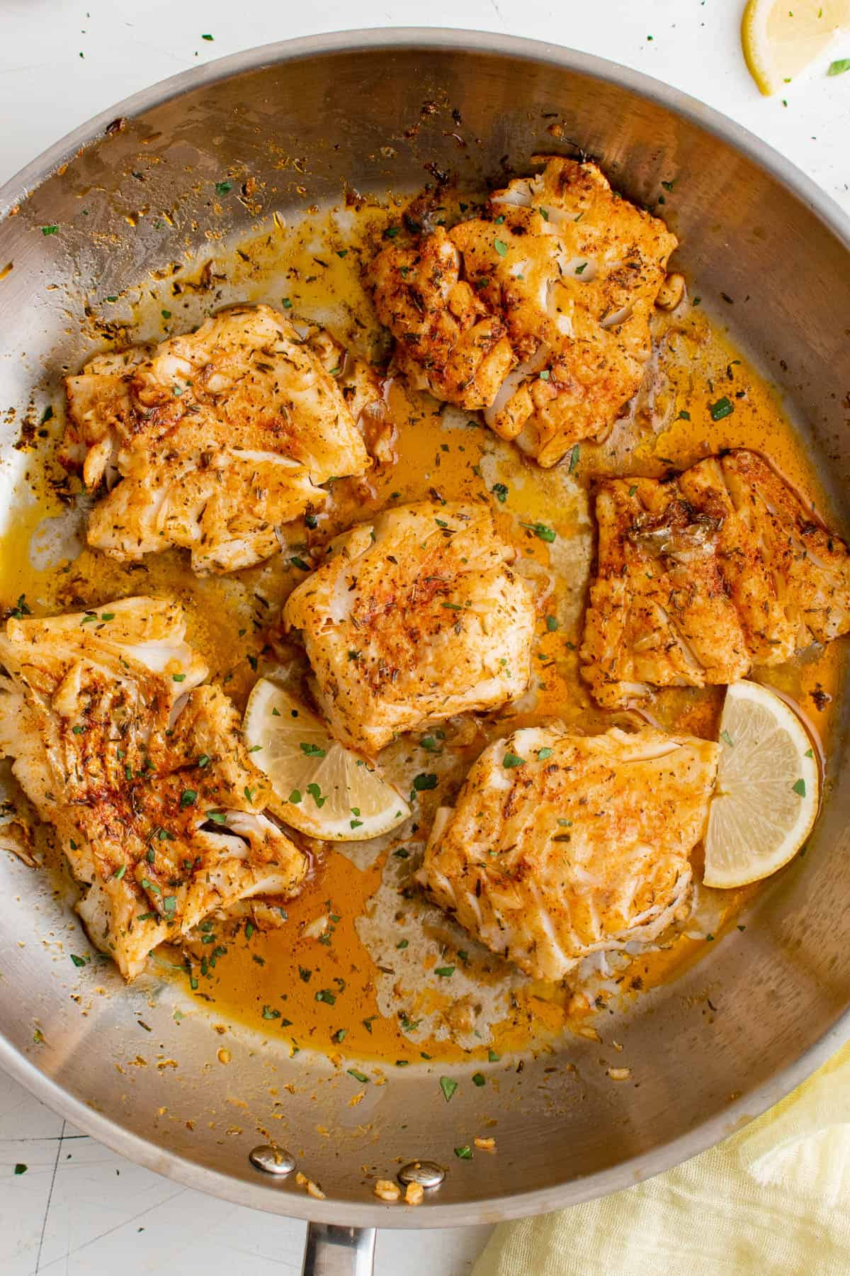 bacalhau queimado numa frigideira com rodelas de limão