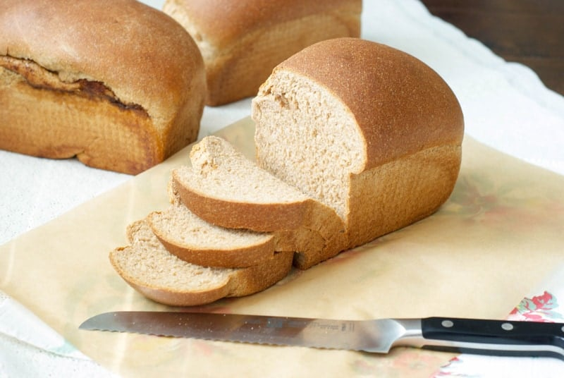 Uma dose lateral de um pão de trigo 100% integral cortado em fatias