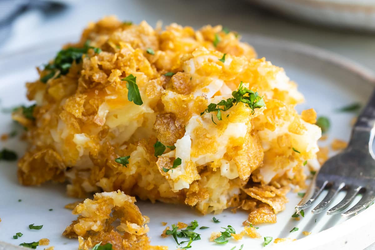Uma pilha de batatas com queijo numa caçarola num prato.