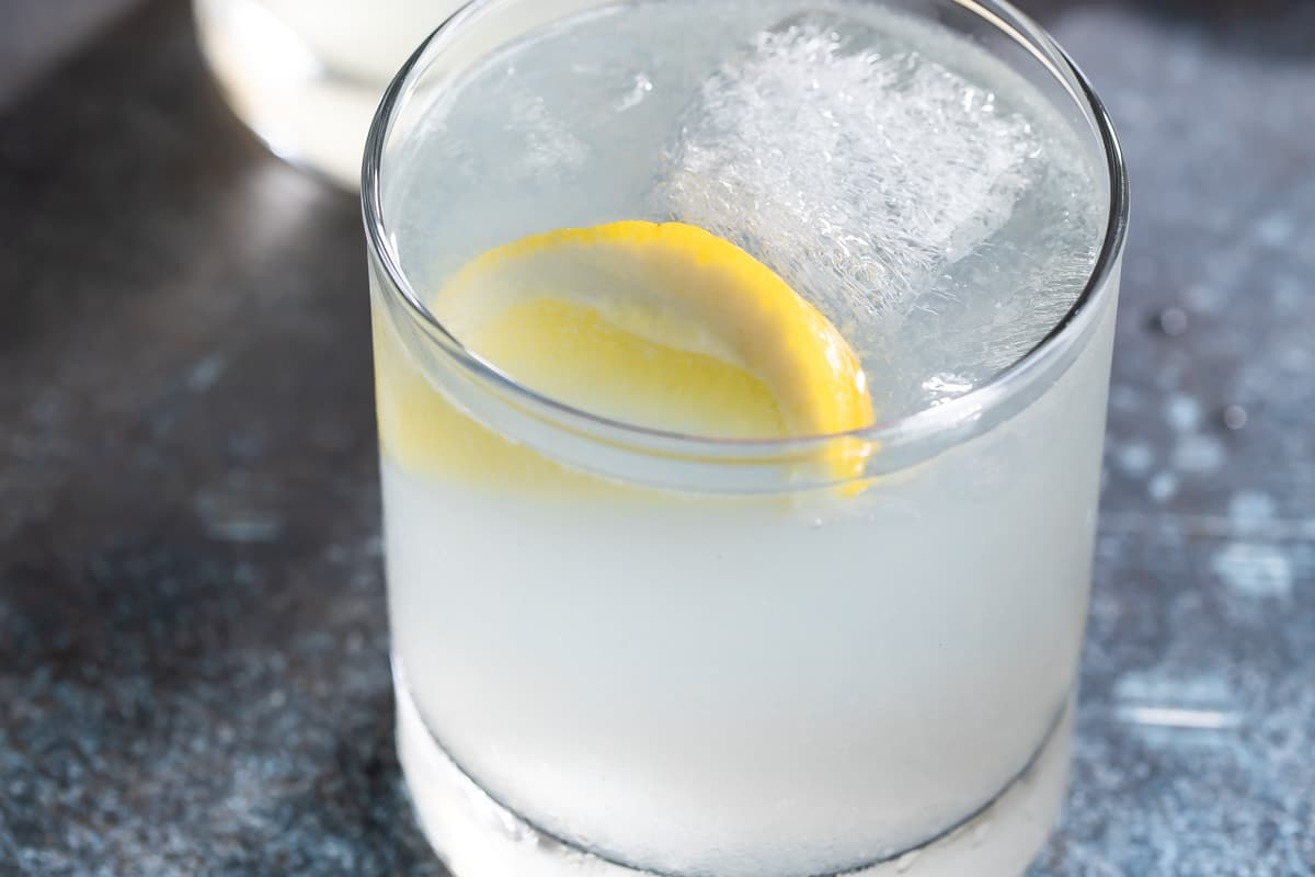 Um cocktail de gin fizz em vidro com um limão.