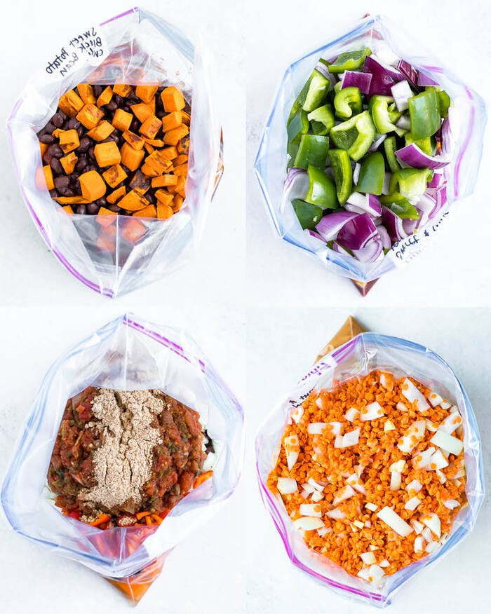 4 sacos de congelação com comida vegetariana congelada. As refeições no congelador incluem chili vegetariano, tempeh doce e azedo, quinoa mexicana cozida e ensopado de lentilhas vermelhas.
