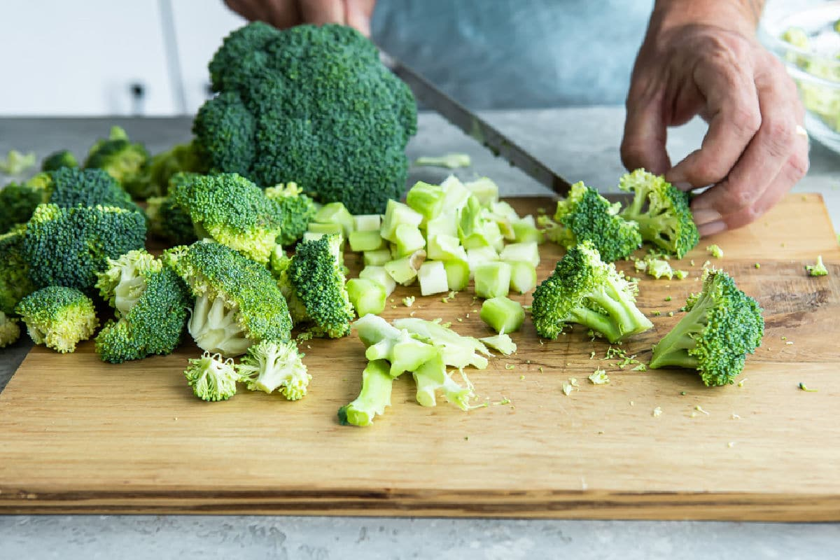 Cortar brócolos numa tábua de cortar.
