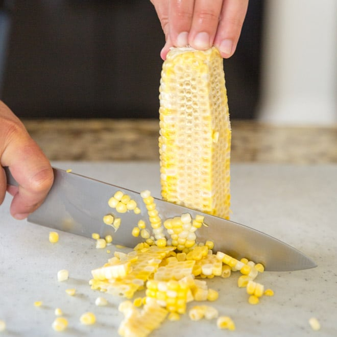 O milho a ser cortado de uma espiga.