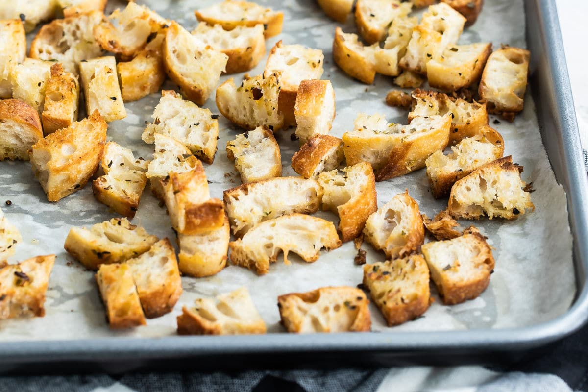 Croutons em uma assadeira forrada com pergaminho.