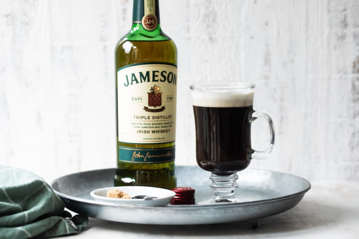 Um tabuleiro com Irish Coffee e uma garrafa de whisky Jameson Irish.