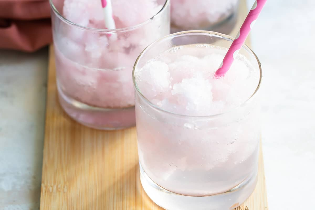 Vodka limonada cor-de-rosa num copo curto e transparente.