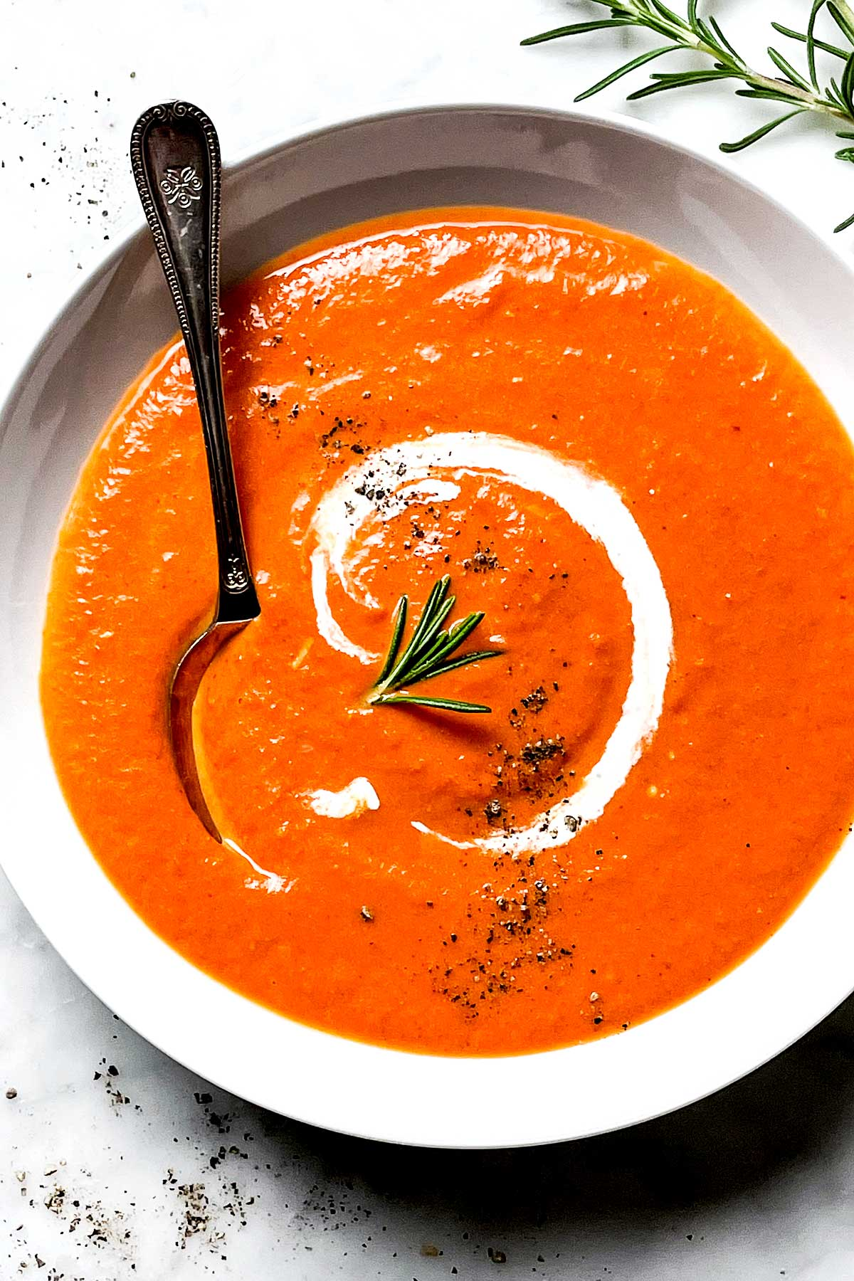 Sopa de Tomate e Pimenta Vermelha Assada em tigela com colher de sopa foodiecrush.com
