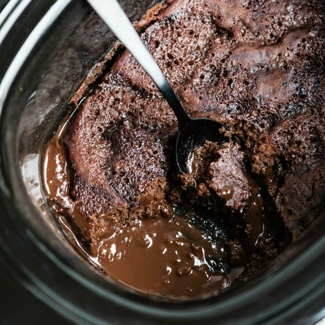 Bolo de lava de chocolate de fogão lento em fogão lento com uma colher de prata.