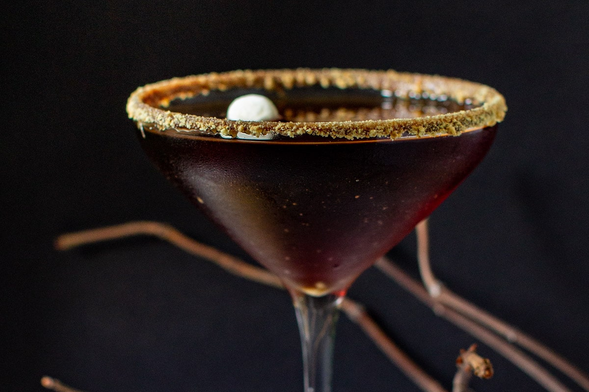Um s'mores martini de chocolate num copo de martini.