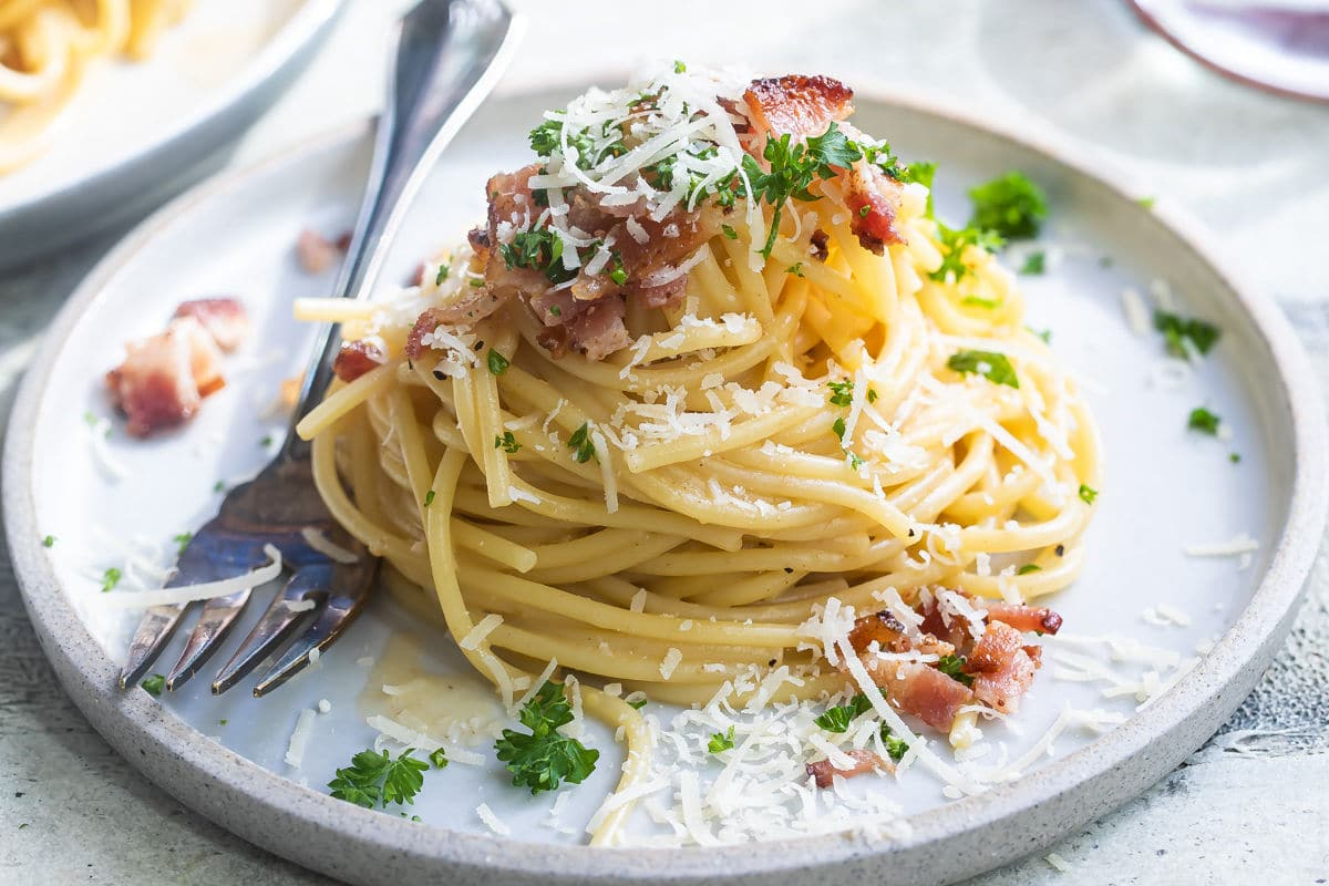 Spaghetti carbonara em placas brancas.