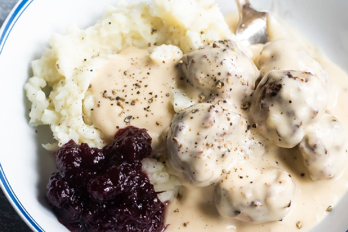 Almôndegas suecas em pratos com puré de batata, molho de molho de molho e arando.