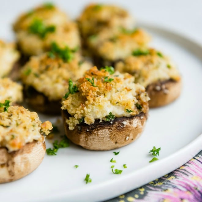 Cogumelos vegetarianos recheados em um prato branco.