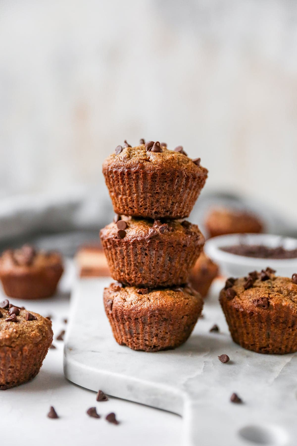 Pilha de três queques de farinha de amêndoa com pedaços de chocolate.