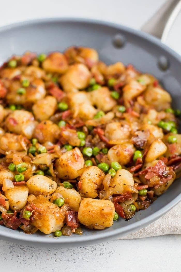 Skillet de nhoque de couve-flor do Trader Joe, salteado com cebola, ervilhas e bacon de peru.