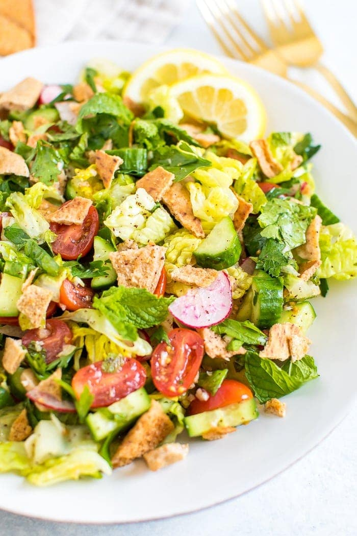 Prato de salada fattoush feita com alface, ervas aromáticas, tomate, pepino, rabanetes e batatas fritas pita esfarrapadas.