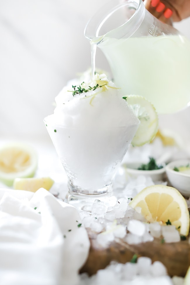 líquido Limoncello a ser vertido num copo de cocktail com gelo raspado.