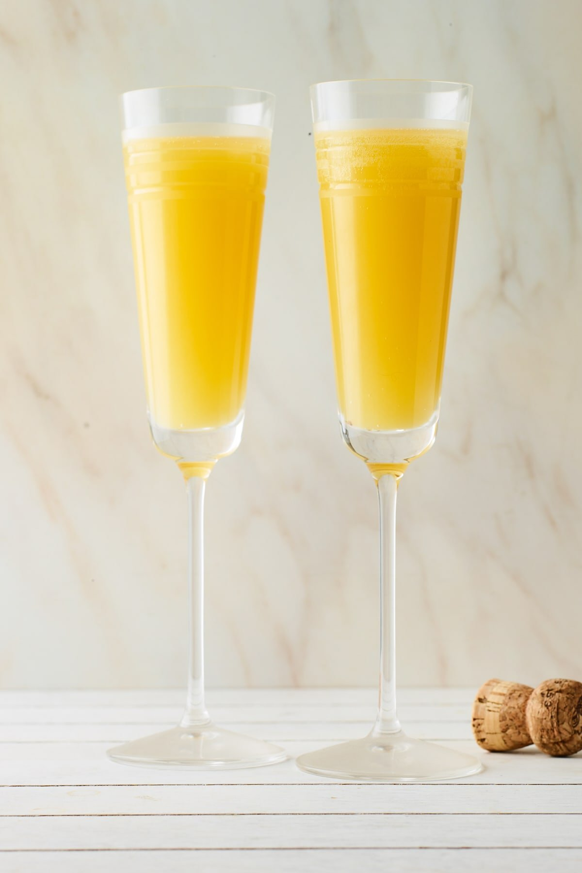Duas flautas de champanhe contendo mimosas.