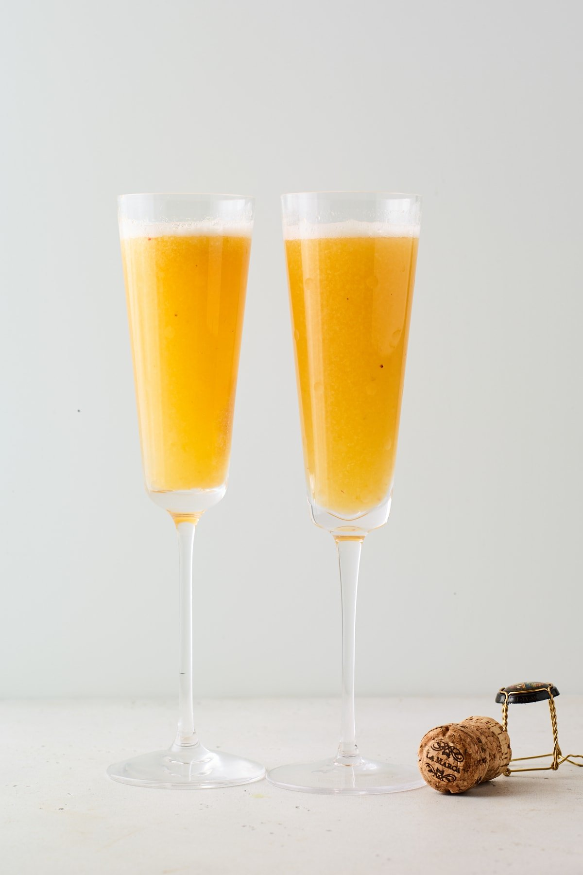 Duas flautas de champanhe contendo uma Bellini de pêssego fácil.