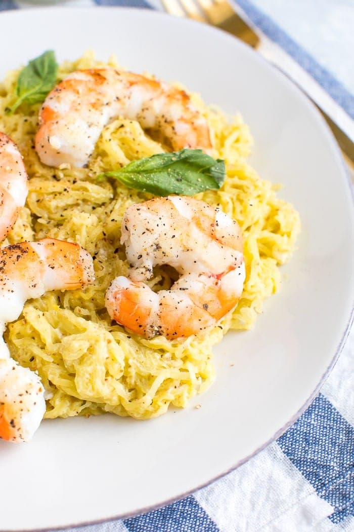 Pesto spaghetti squash coberto com camarão e manjericão.